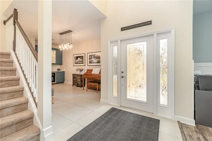 Entry featuring light tile patterned floors and glass front door