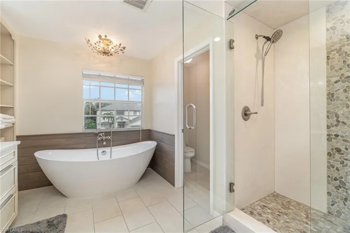 Full bathroom featuring shower with separate bathtub, water closet, and tile patterned floors