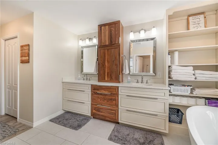 Bathroom with a bath, tile patterned flooring, and vanity