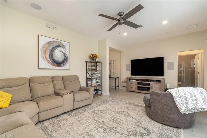 Tiled living room featuring ceiling fan and recessed lighting