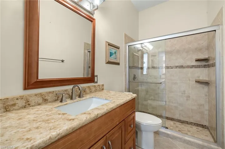 Bathroom with vanity, a shower stall, and light tile patterned flooring