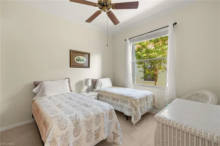 Carpeted bedroom featuring ornamental molding and a ceiling fan