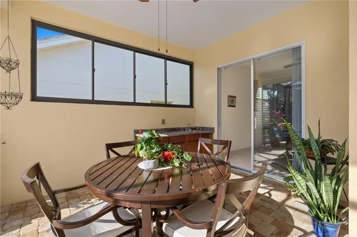 Dining space with ceiling fan and stone tile floors