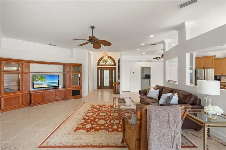 Living room featuring light tile patterned flooring, recessed lighting, and ceiling fan