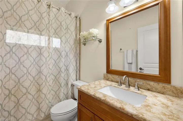 Full bath with curtained shower and vanity