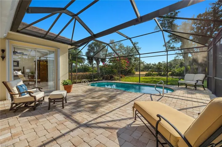 Outdoor pool with a patio, a sunroom, and a lanai