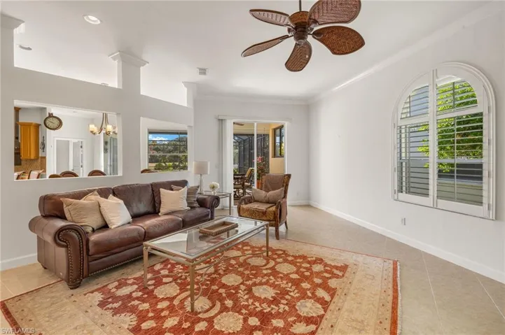 Living area with light tile patterned floors, crown molding, a chandelier, a ceiling fan, and recessed lighting
