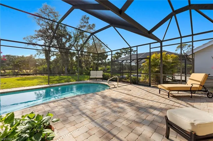 Swimming pool featuring glass enclosure, a sunroom, and a patio