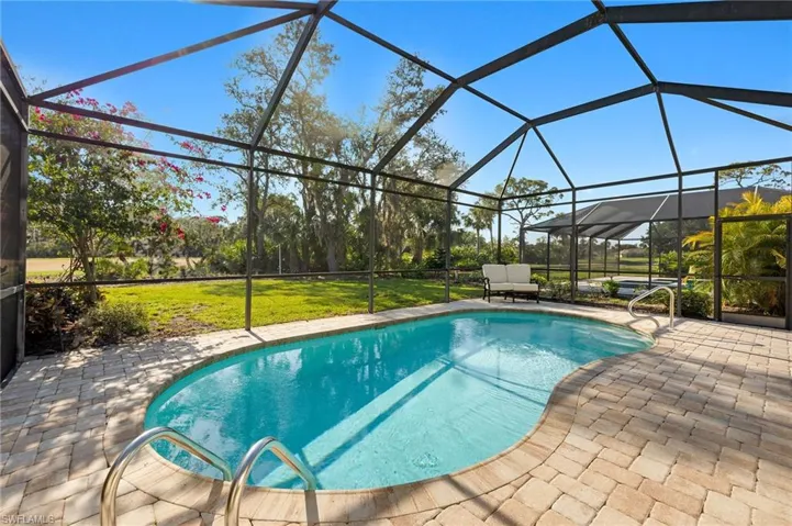 Outdoor pool with a sunroom, a lanai, a patio, and a yard
