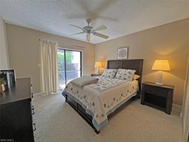 Roomy guest bedroom with queen bed and sliders to courtyard