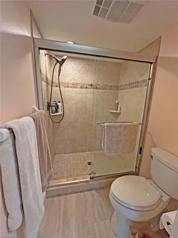 En suite featuring double vanity, walk-in shower, and walk-in closet