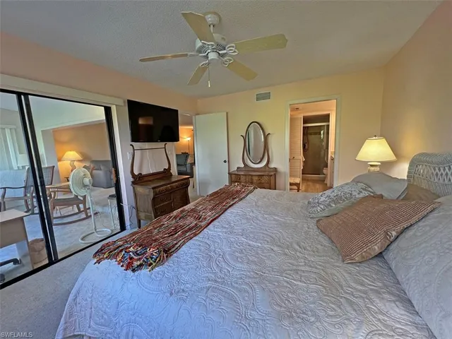 Spacious primary bedroom with queen bed and TV