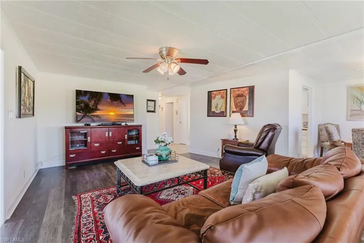 Living area with dark wood-style floors and ceiling fan
