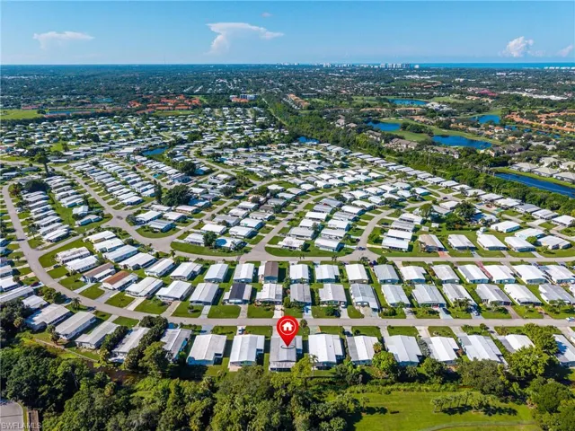 Aerial view of property and surrounding area with a large body of water and nearby suburban area
