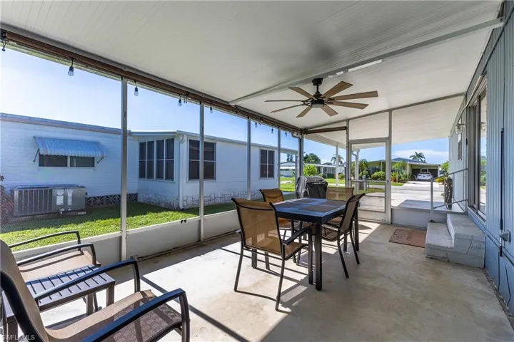 Sunroom / solarium with outdoor dining space and ceiling fan