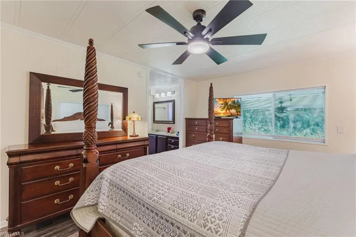 Bedroom featuring ornamental molding, ceiling fan, wood finished floors, and ensuite bathroom
