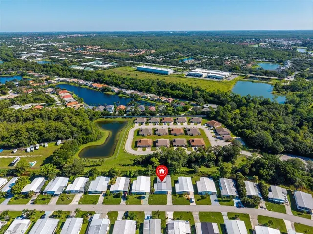 Aerial view of property and surrounding area with a nearby body of water and nearby suburban area
