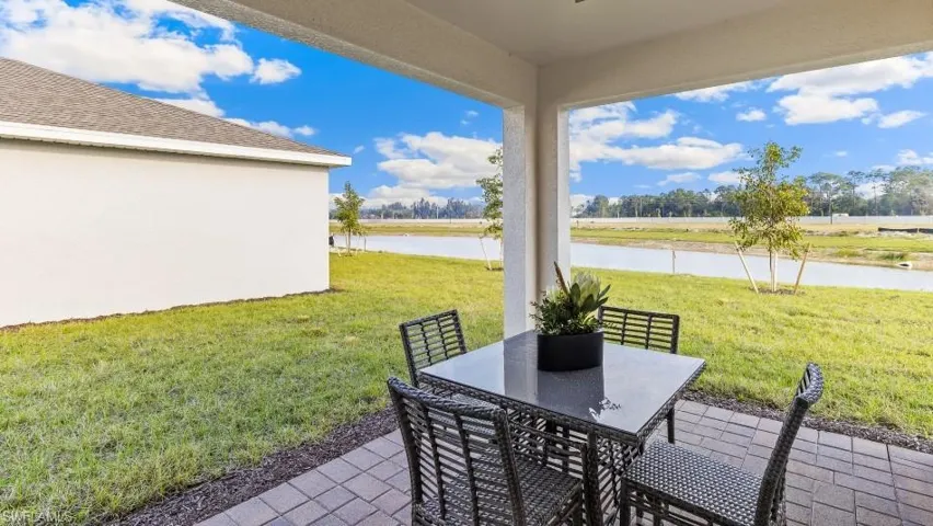 Model home. View of patio / terrace with a water view and outdoor dining space