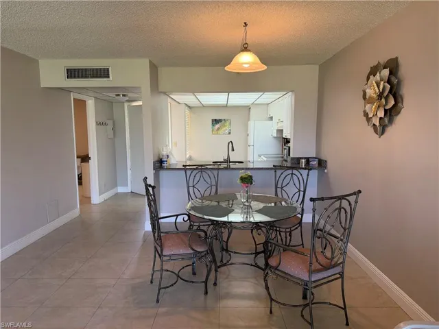 Dining space featuring a textured ceiling and light tile patterned floors