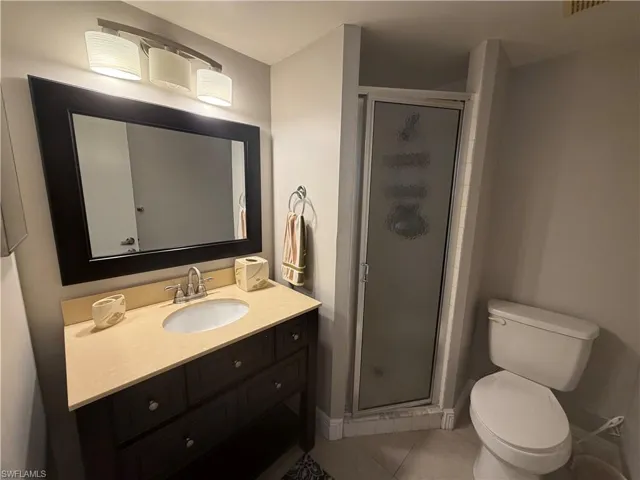 Bathroom with a shower stall, vanity, and light tile patterned floors