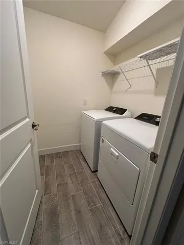 Washroom featuring wood tiled floors and washing machine and dryer