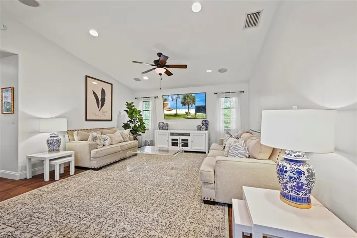 Living area featuring vaulted ceiling, recessed lighting, wood finished floors, and ceiling fan