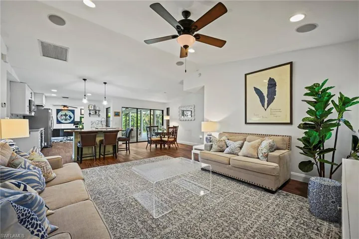 Living room with ceiling fan, dark wood finished floors, recessed lighting, and vaulted ceiling