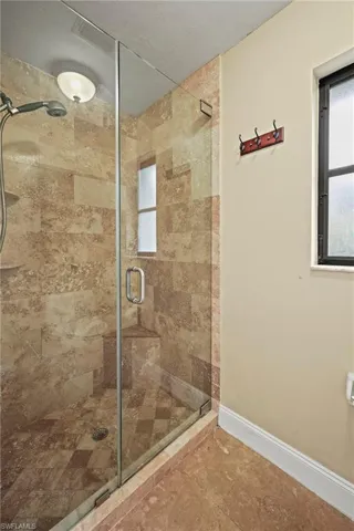 Bathroom featuring a stall shower and baseboards