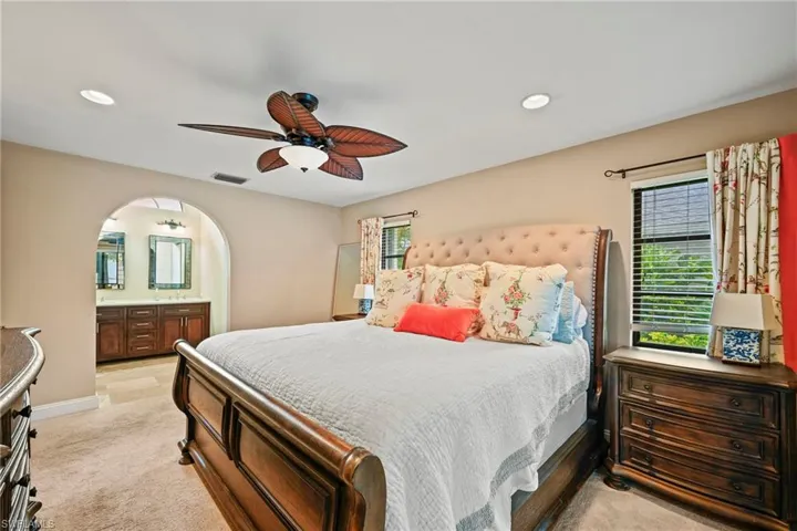 Bedroom with light colored carpet, ceiling fan, and recessed lighting