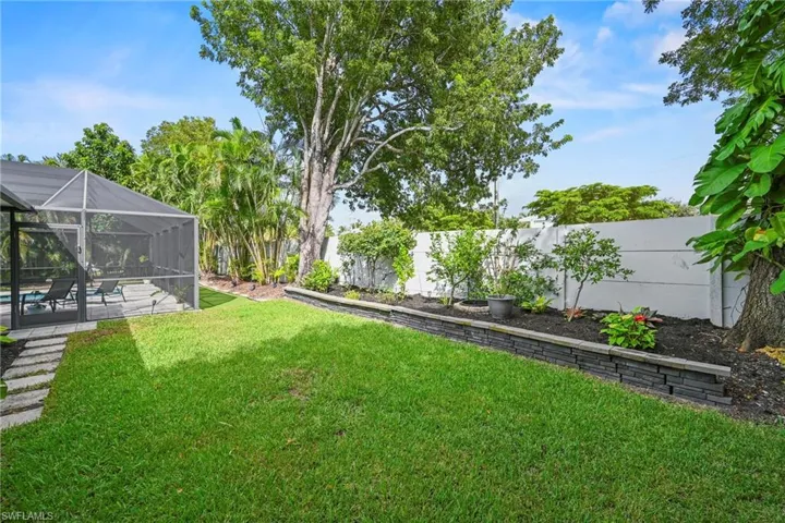 Fenced backyard with glass enclosure, a swimming pool, and a sunroom