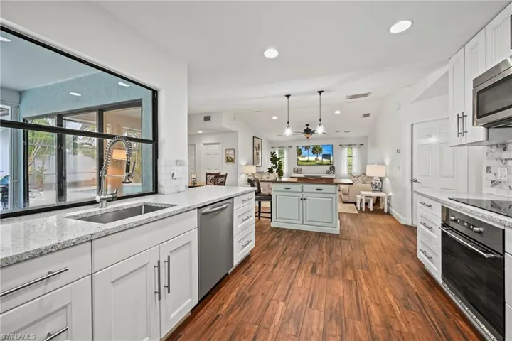 Kitchen with recessed lighting, light stone countertops, tasteful backsplash, and white cabinets