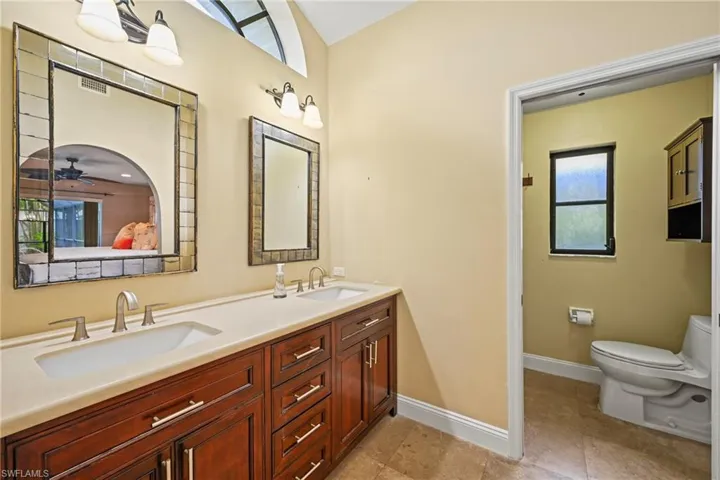 Full bath featuring double vanity and ceiling fan