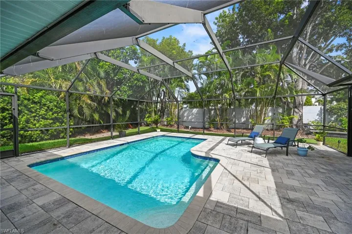 Swimming pool featuring screened enclosure, and paved patio
