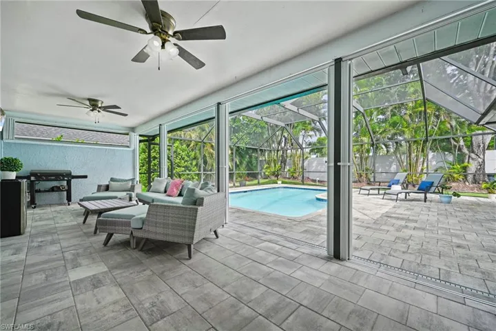 Outdoor pool featuring a screened eclosure, an outdoor living space, a patio area, and a ceiling fan