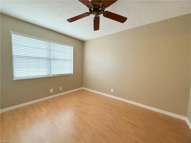 Spare room with a textured ceiling, light wood-type flooring, and ceiling fan