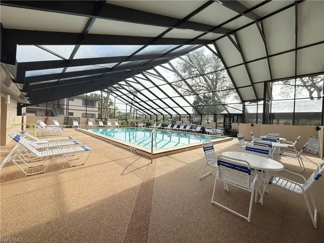 View of pool featuring glass enclosure and a patio area