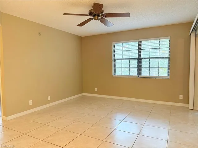 Tiled spare room with a textured ceiling and ceiling fan