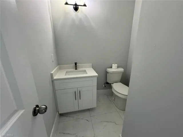 Bathroom featuring vanity, tile patterned flooring, and toilet