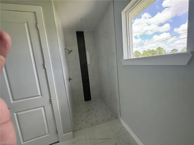 Bathroom featuring tile patterned flooring and a tile shower