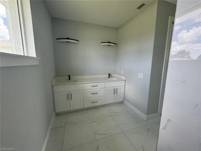 Bathroom featuring double vanity and tile patterned floors