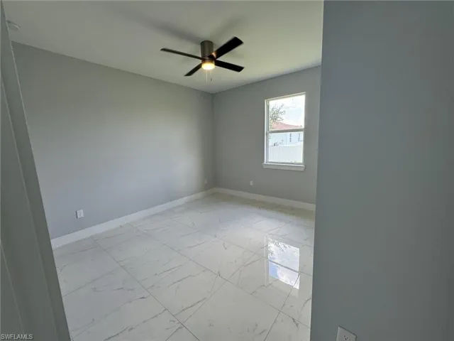 Unfurnished room with light tile patterned floors and ceiling fan
