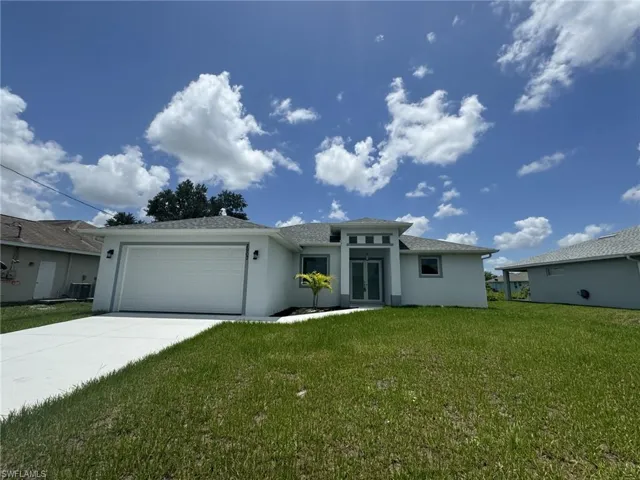 View of front of house with a garage, a front lawn, and central AC unit