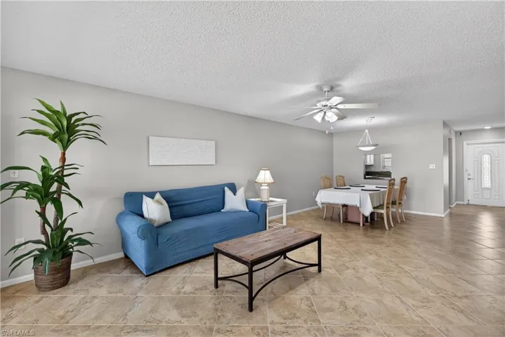 Living area with a ceiling fan/light and tile floors