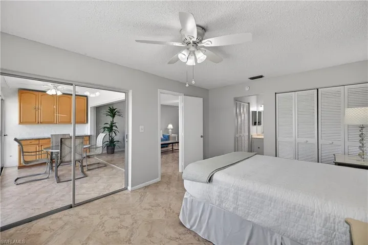 Primary bedroom featuring two closets, a ceiling fan and tile floors.