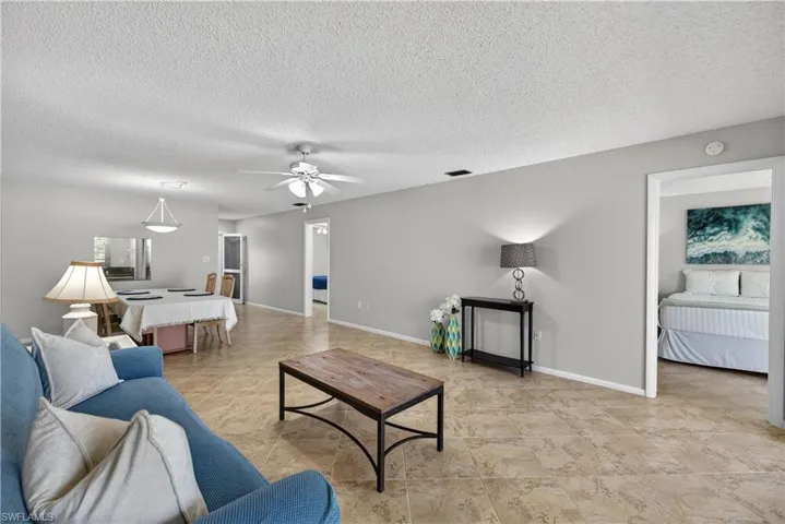 Living room with ceiling fan/light and matching tile floors throughout