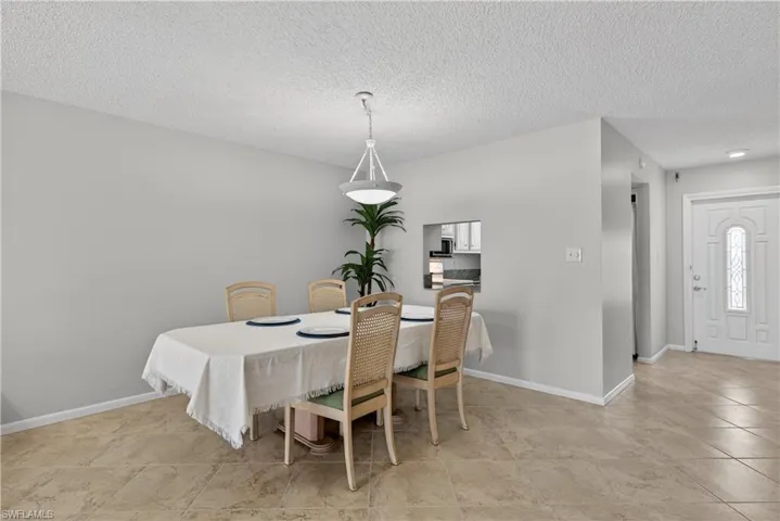 Dining room with overhead lighting and matching tile floors throughout