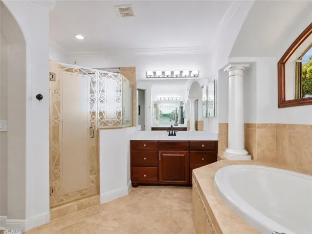 Primary bath be soaking tub to vanity, sinks, and walk in the shower