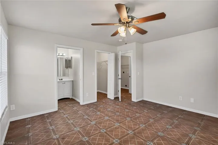 Patterned tile flooring, ceiling fan with integrated lighting, window with blinds, and white interior doors