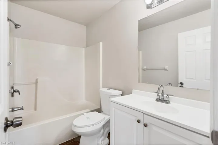 White vanity with dual-door cabinetry, polished chrome faucet, and integrated sink