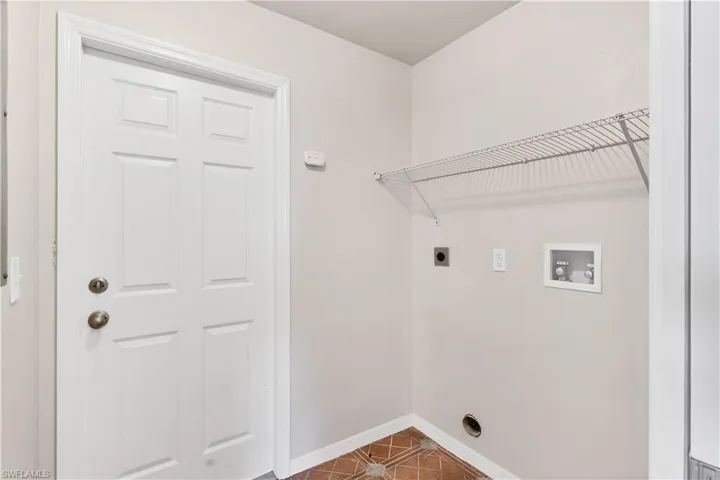 Laundry area featuring a wire shelf, utility hookups, and a paneled door